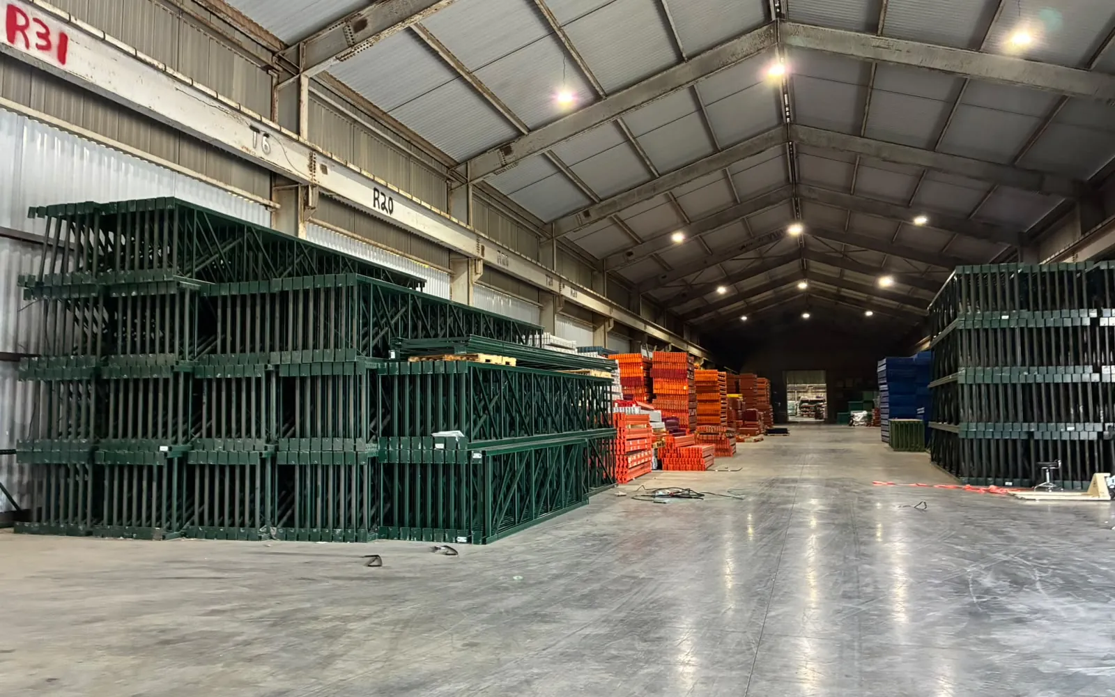 Pallet rack upright frames and beams stacked inside the United Rack Solutions warehouse